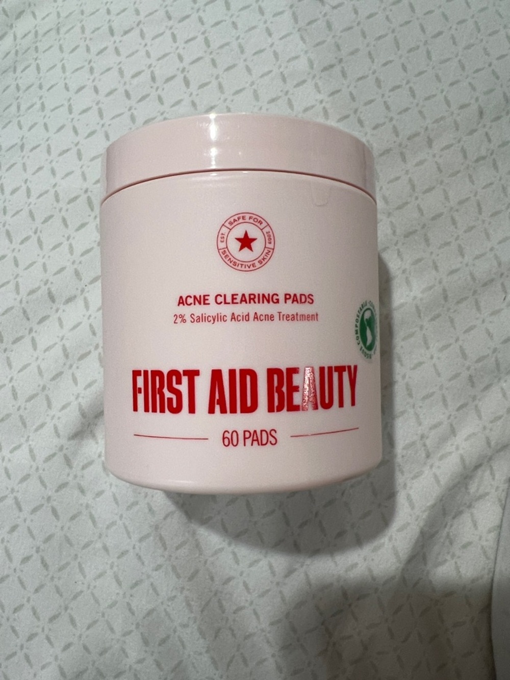 First Aid Beauty Acne Clearing Pads - Light Pink Jar with Red Text